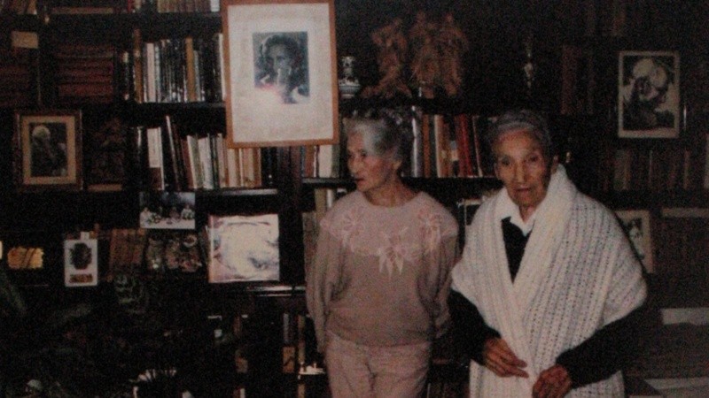 Leticia, la menor de las Cossettini,y Olga, con la biblioteca de fondo.